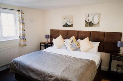 a bedroom with a large bed with pillows on it at The Cricketers Arms in Quendon