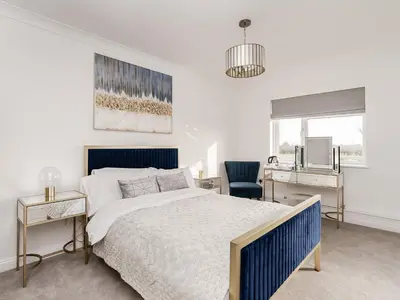 a bedroom with a blue and white bed and a desk at Pike & Eel Hotel and Marina in Needingworth