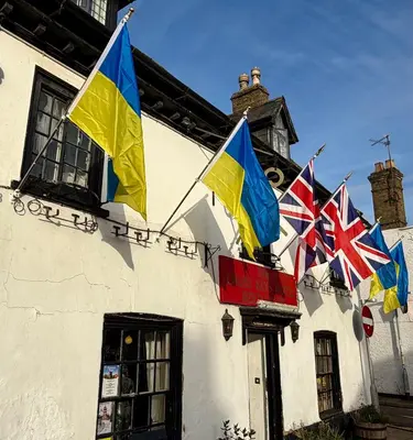 a group of flags on the side of a building at Cross Keys Hotel Chatteris in Chatteris