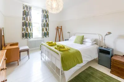 a bedroom with a bed with yellow towels on it at Watermans in Aldeburgh