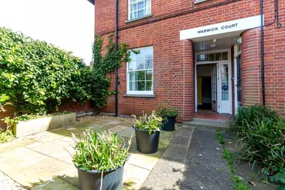 a brick building with two potted plants in front of it at Watermans in Aldeburgh
