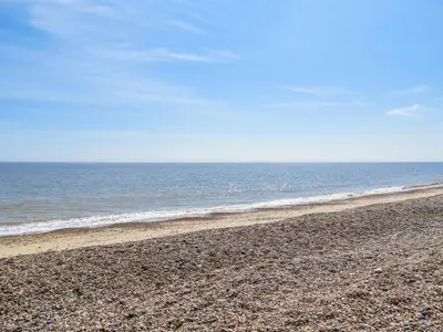 a rocky beach with the ocean in the background at Watermans in Aldeburgh