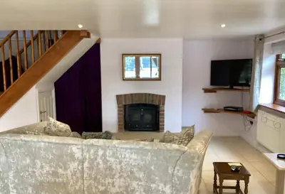 a living room with a couch and a fireplace at The little house in West Hanningfield