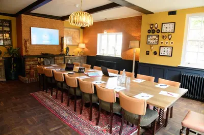 a conference room with a long table and chairs at The White Horse in Hertingfordbury