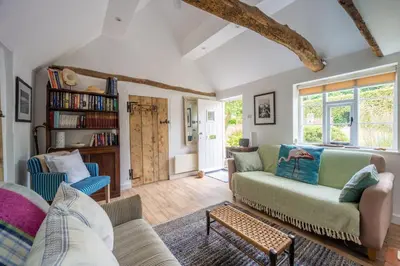 a living room with a couch and chairs at Myrtle Cottage in Friston