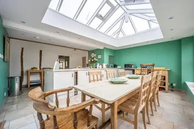 a kitchen and dining room with a table and chairs at Myrtle Cottage in Friston