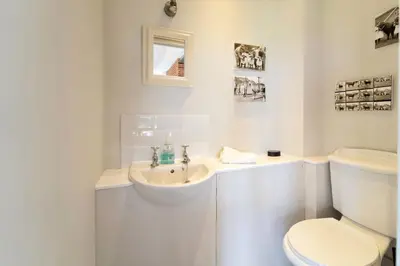 a white bathroom with a sink and a toilet at The Dairy in Freston