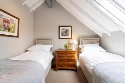 two twin beds in a room with a dresser between them at The Dairy in Freston