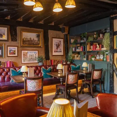 a restaurant with couches and tables and chairs at Salisbury Arms Hotel in Hertford