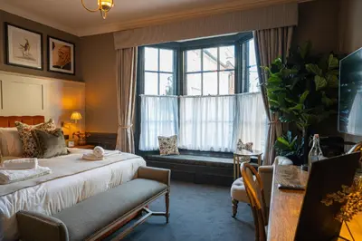 a bedroom with a bed and a large window at Salisbury Arms Hotel in Hertford