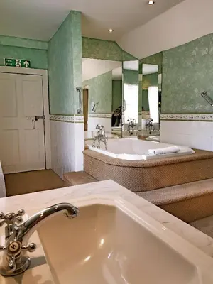 a bathroom with a tub and a large sink at The Crown House Inn in Great Chesterford