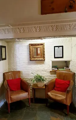 two chairs with red pillows sitting next to a table at The Crown House Inn in Great Chesterford