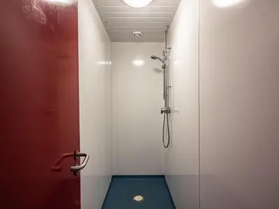 a bathroom with a shower with a glass door at YHA London Lee Valley in Cheshunt