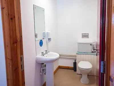 a bathroom with a sink and a toilet and a mirror at YHA London Lee Valley in Cheshunt