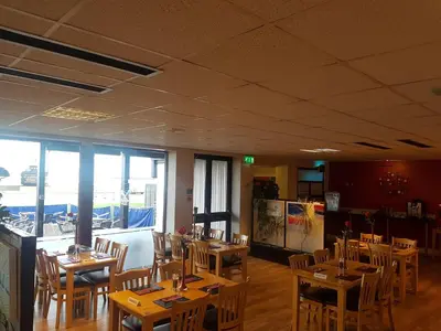 a restaurant with wooden tables and chairs in a room at The Shipwreck Loft in Shotley Gate