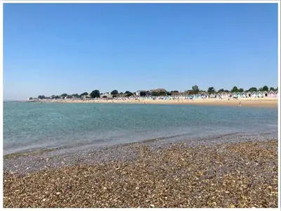 a beach with a rocky shore and the ocean at The retreat in West Mersea