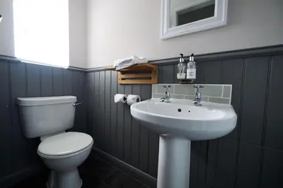 a bathroom with a toilet and a sink at White Hart, Newmarket by Marston's Inns in Newmarket