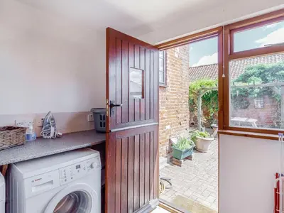 a kitchen with a washer and dryer next to a window at Horseshoe in Little Glenham