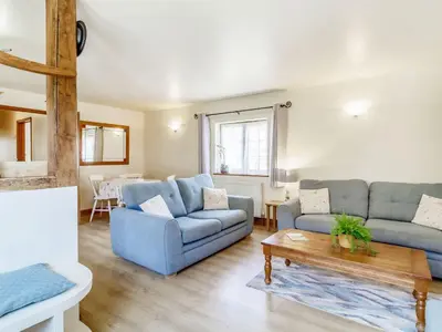 a living room with two blue couches and a table at Horseshoe in Little Glenham