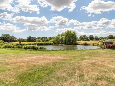a view of a pond in a field at Horseshoe in Little Glenham