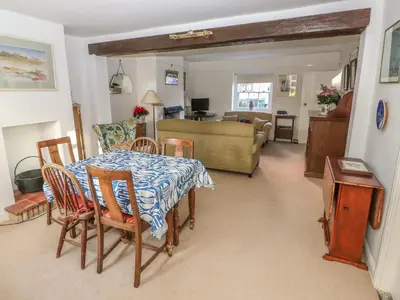 a dining room and living room with a table and chairs at 28 Oxborough in Oxborough