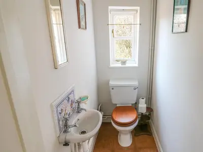 a bathroom with a toilet and a sink and a window at 28 Oxborough in Oxborough