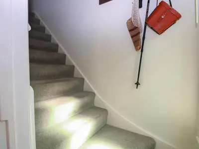 a staircase with a purse and a handbag on the wall at Peggotty's in Kelsale