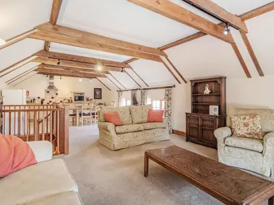 a living room with two chairs and a table at Punch Cottage in Little Glenham