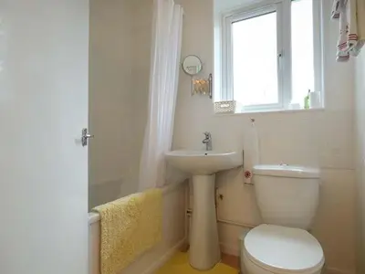 a bathroom with a toilet and a sink and a window at Spurling Cottage in Cheveley