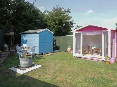 a shed and a gazebo in a yard at Spurling Cottage in Cheveley