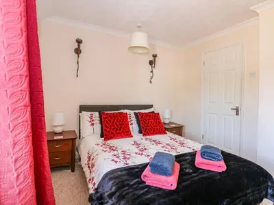 a bedroom with a bed with two towels on it at Cameron's Cottage in Swaffham