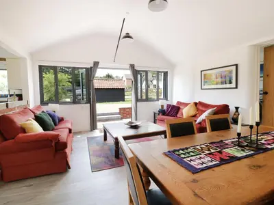 a living room with a table and a couch at Whitehands Farm Barn in Old Buckenham