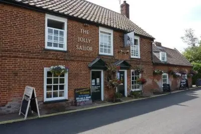 a red brick building on the side of a street at Crown Cottage, Orford - Prime Orford Location in Orford