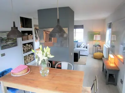 a living room with a vase of flowers on a table at Crown Cottage, Orford - Prime Orford Location in Orford