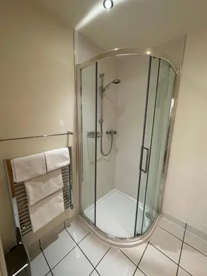 a bathroom with a shower with a mirror at Meadows Barn in Chelmsford