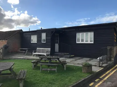 a house with a picnic table and benches in the yard at The Black Bull Inn in Fyfield