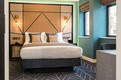 a bedroom with a large bed with a large headboard at Seven Hotel in Southend-on-Sea