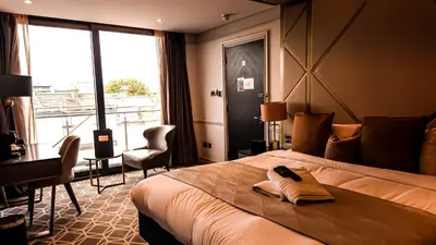 a hotel room with a bed and a desk and a window at Seven Hotel in Southend-on-Sea
