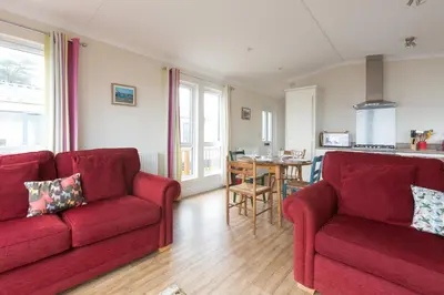 a living room with two red couches and a table at Sole Bay View in Sizewell