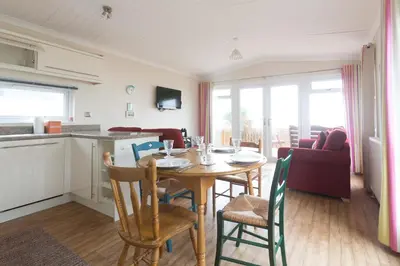 a kitchen and dining room with a table and chairs at Sole Bay View in Sizewell