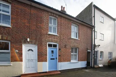 a red brick building with a blue door and windows at Pugwash in Aldeburgh