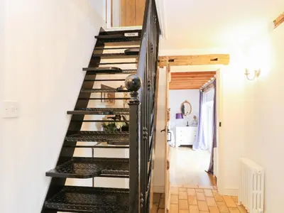 a black spiral staircase in a room with a bathroom at Stable Cottage in West Bradenham