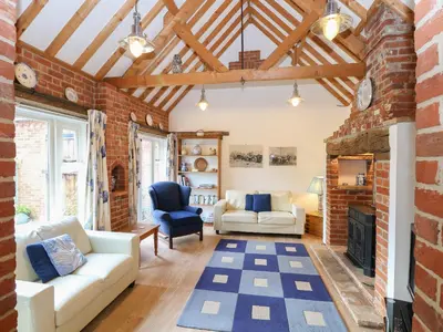 a living room with a brick wall at Stable Cottage in West Bradenham