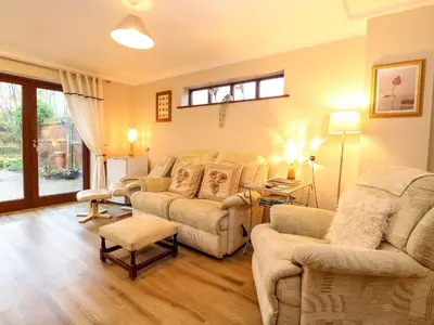 a living room with a couch and chairs and a table at Kingfisher in Wattisfield