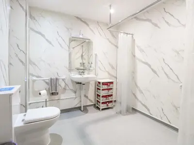 a white bathroom with a toilet and a sink at Kingfisher in Wattisfield