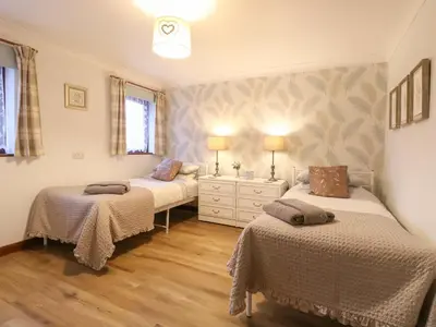 a bedroom with two beds and a dresser in it at Kingfisher in Wattisfield