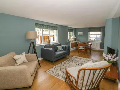 a living room with a couch and a chair at Mulberry Cottage in Hadleigh