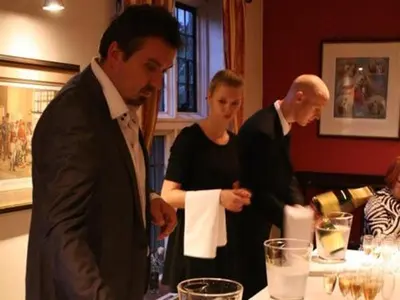 a group of people standing around a table with wine glasses at The Black Bull Inn in Balsham