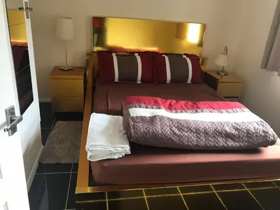 a bedroom with a bed with a wooden headboard at Waltham Abbey Private Property in Waltham Abbey