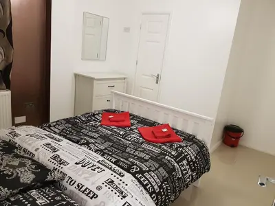 a bedroom with a bed with two red pillows on it at Observation Court in Ipswich